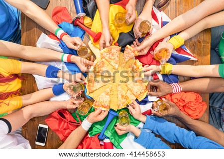 Top view of multiethnic hands of football sport supporter sharing pizza margherita - Friendship concept with soccer fans enjoying food together - People eating at party bar pub after sport match event