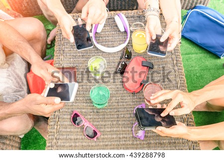 Top view of multiracial friends with mobile smartphone - Addiction concept using new tech devices - People having fun on social media networking - Warm vintage filter - Focus on lower hands and phones