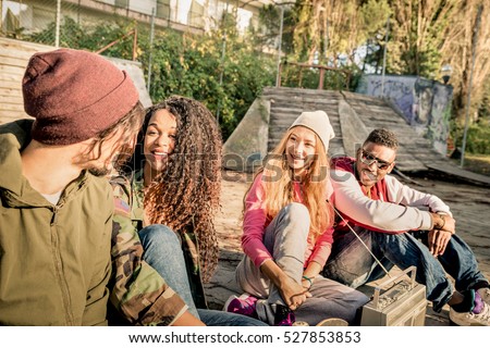 Group of urban style friends having fun time out at skate bmx park - Youth friendship concept with people together outdoors - Focus on african american young woman - Desaturated contrasted filter