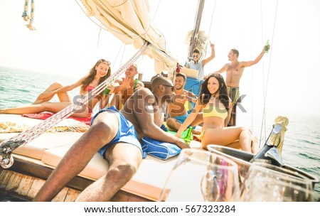 Group of multiracial friends having fun at sail boat party with dj set - Friendship concept with young multi racial people on sailboat - Travel lifestyle on exclusive vibe mood - Warm bright filter