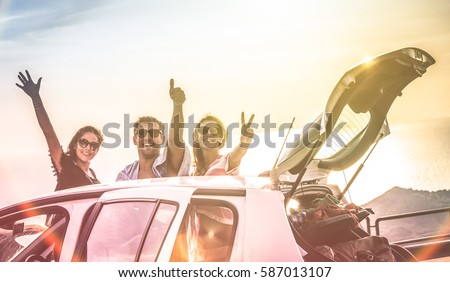 Group of best friends cheering on car road trip at sunset - Happy people outdoor on vacation tour adventure - Friendship concept at travel together around world - Soft focus with vintage color filter