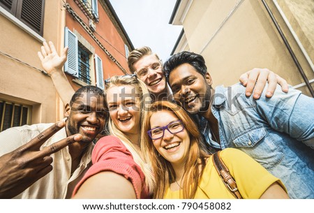 Best friends multiracial people taking selfie outdoors - Happy friendship concept with young students having fun together - Peace and love against racism - International exchange concept - Warm filter