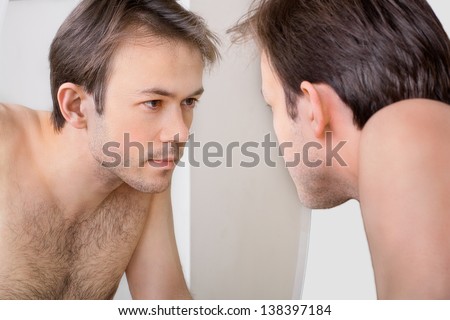 Man checks his reflection in the mirror in early morning