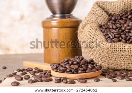 coffee bean on wood scoop ,coffee bean in bag and coffee grinder on brown wooden background