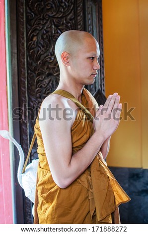 UBONRATCHATHANI, THAILAND - JANUARY 18 ; An unidentified new buddhist monk standing and praying  in the chapel  on January 18,2014  in Ubonratchathani, Thailand