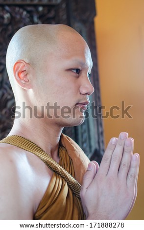 UBONRATCHATHANI, THAILAND - JANUARY 18 ; An unidentified new buddhist monk standing and praying  in the chapel  on January 18,2014  in Ubonratchathani, Thailand