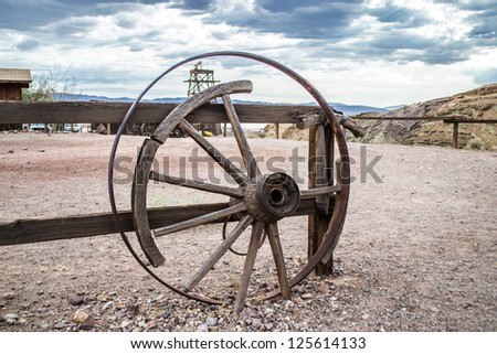 Broken cart wheel on wild west with blue sky