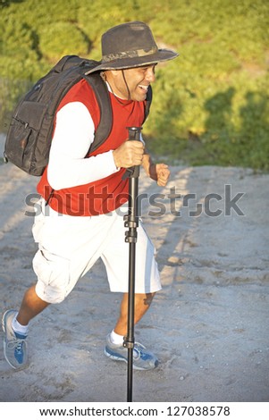 Full length of mid adult man with backpack on a mountain hike. Vertical shot.