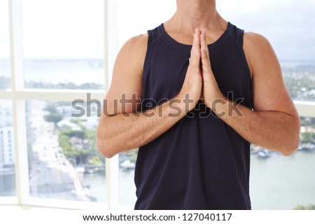 Caucasian male doing yoga prayer pose indoors in high  rise apartment