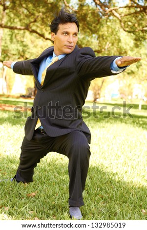 Businessman performing yoga at the park. Vertical Shot.
