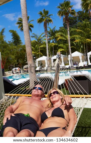 Mature White Male And Woman Relaxing In Hammock On Vacation