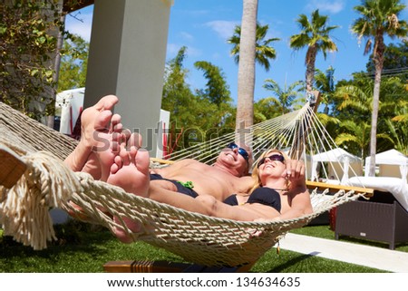 Mature White Male And Woman Relaxing In Hammock On Vacation