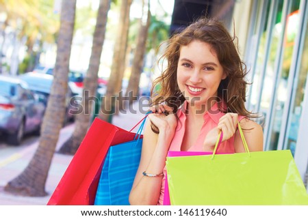 Smiling beautiful woman with shopping bags looking away. Horizontal Shot.
