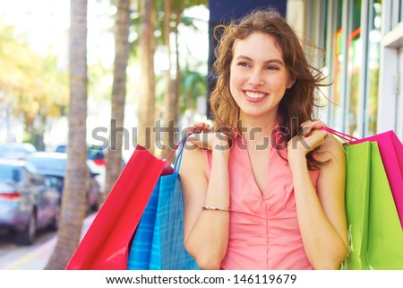 Smiling beautiful woman with shopping bags looking away. Horizontal Shot.