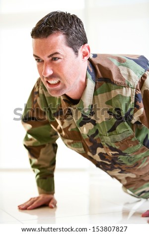 White male in army uniform straining doing a push up