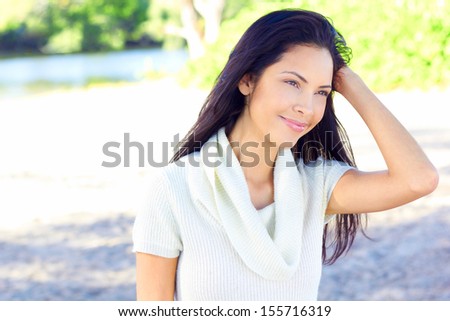 Beautiful happy young multi ethnic fashion model near the sea with clear skin and long silky flowing hair with copy space