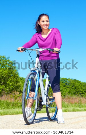 Happy Young Pretty Mixed Race Woman Riding Bike On The Trail In The Forest Preserve. Cute Asian Female Riding Bicycle On A Beautiful Spring Day. Copy Space, Color Image.