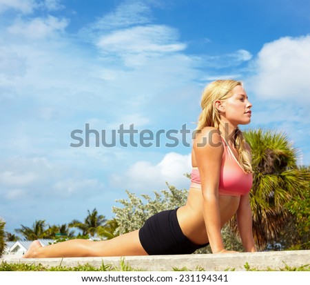 Full length side view of beautiful young woman practicing cobra posture at park