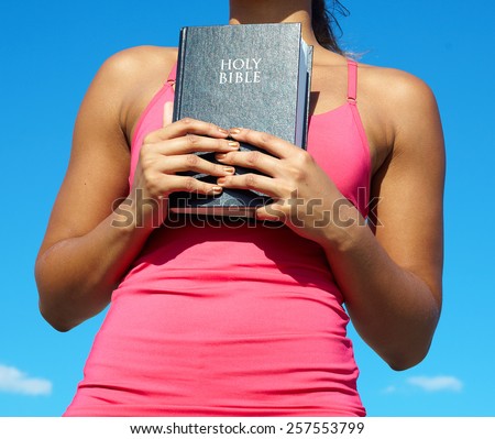 African American Woman Holding Bible Which Is The Word Of God, Sharper Than Any Double Edged Sword, Piercing Through Bone And Marrow, Which is The Sword Of The Spirit.