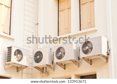 Four air condition box on side of building