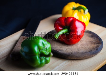 Colorful paprika, food styling on wood with knife