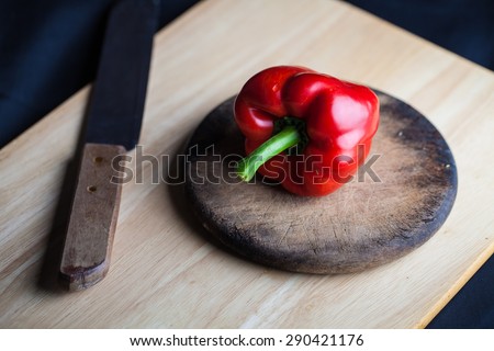 Red paprika, food styling on wood  with knife