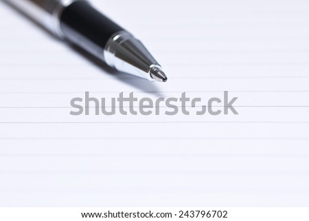 Close up of pen tip on a blank notebook