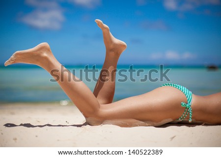 Women's beautiful legs on the beach