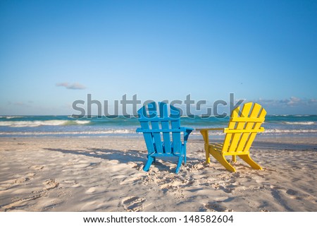 Beach wooden colorful chairs for vacations on tropical beach in Tulum, Mexico
