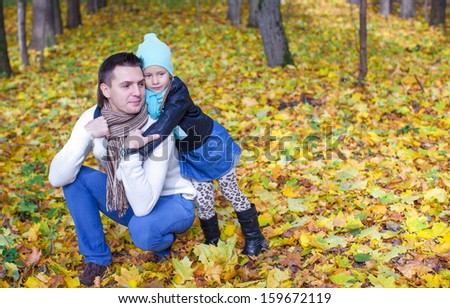 Cute little daughter with young daddy enjoy their autumn vacation on a sunny day