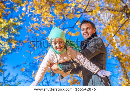 Cute little girl with happy daddy enjoy their autumn vacation on a sunny day