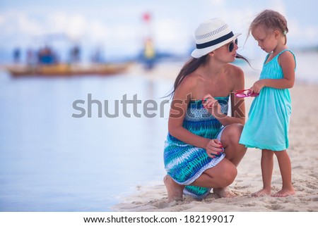 Little girl and young mother on tropical beach in desert island