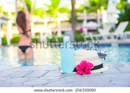 Woman, suncream, hat, sunglasses, flower and tower near swimming pool