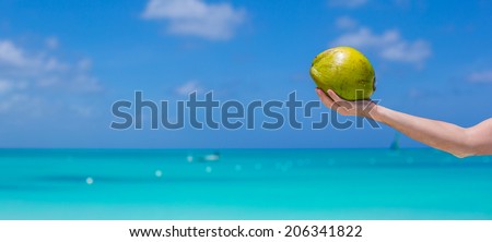 Closeup of coconut in hands background the turquoise sea