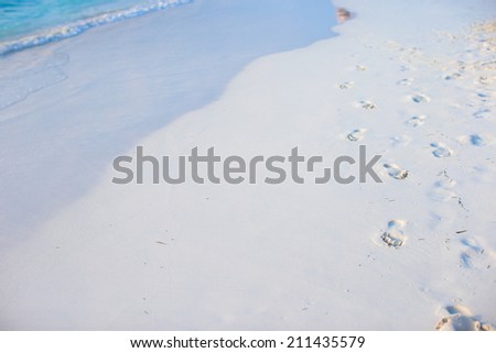 Human footprints on white sand beach