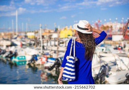 Young beautiful woman relaxing on dock near the boat on sunny day