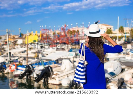Young beautiful woman walking on dock near the boat