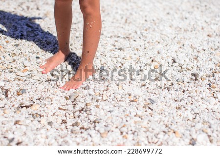 Closeup of little girl feet on tropical sandy beach