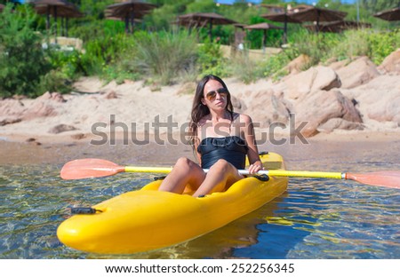 Young beautiful woman kayaking in clear turquoise water