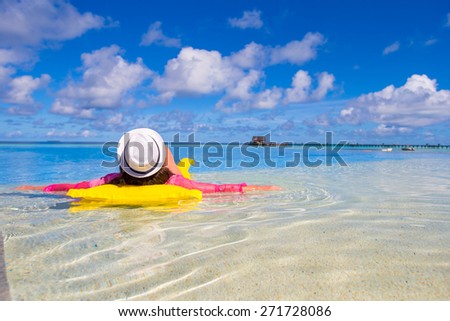 Young happy woman relaxing with air mattress in swimming pool