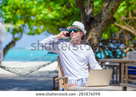 Young man calling by cell phone in outdoor cafe