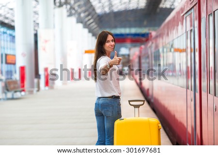 Young caucasian woman with luggage at station traveling by train