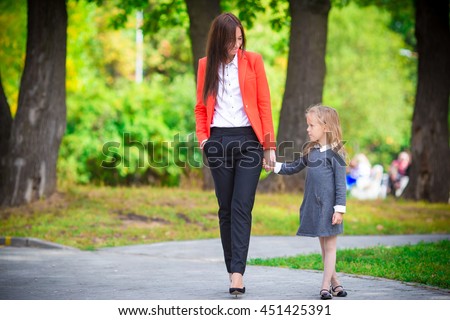 Mother brings her daughter to school. Adorable little girl feeling very excited about going back to school