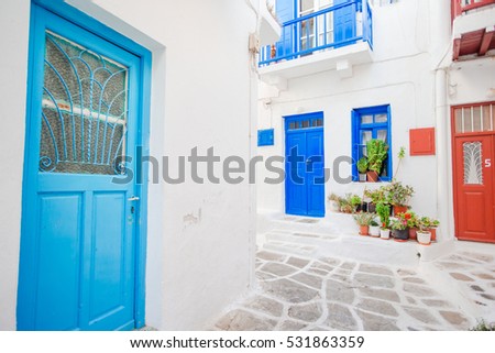 Traditional houses withe blue doors in the narrow streets of Mykonos, Greece.