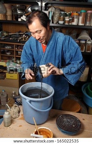 Japanese pottery master/Step by step/Japanese pottery master in his studio performing one of many steps.