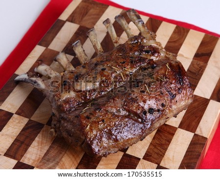 Tasty rack of lamb/Rack of lamb/A tasty rack of lamb straight out of the oven on a chopping board.