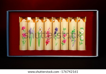 TOKYO, JAPAN - FEBRUARY 14, 2014: A photo of Japanese hand painted candles known as Mitsuro. Originating in China and came to Japan in the Nara period with Buddhism. Shot in box on black and red.