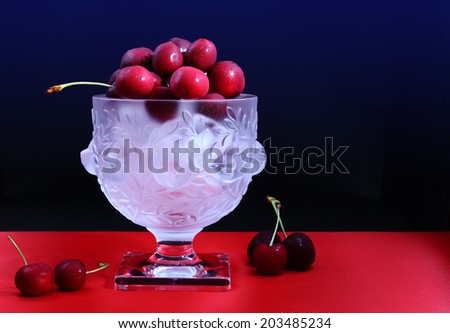 Cherries on ice/Juicy cherries on ice/A photo of fresh juicy cherries on ice presented in a beautiful crystal bowl. Shot in studio.