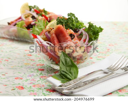 Ham salad/Prosciutto ham salad/A photo of a delicious prosciutto ham salad in a bowl on a pretty floral tablecloth with table setting and white background.