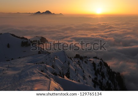 Winter landscape with sunset on the mountain Rigi, in Switzerland - mountain Pilatus can be seen on the background